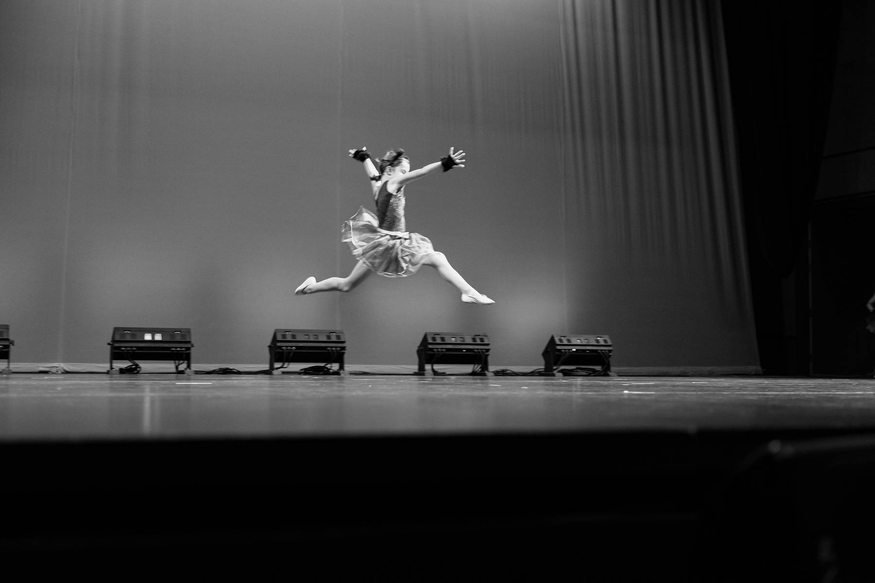 Dancer performing a leap on stage